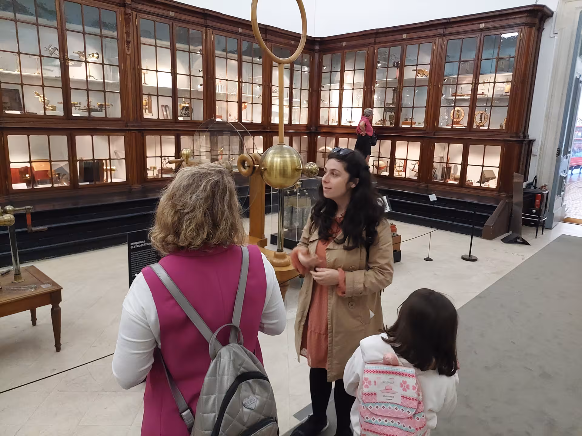 Guide explaining historical scientific instruments to visitors at Coimbra University's science museum.