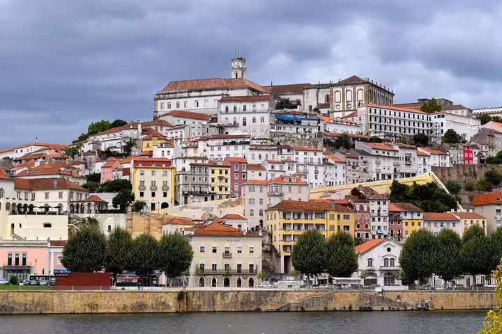 Scenic view of Coimbra's historic hilltop university and colorful buildings, featured in Fatima and Coimbra private tour.