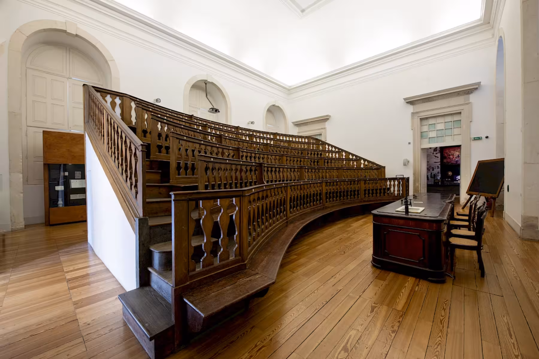 Elegant wooden lecture hall at Coimbra University showcasing historic academic architecture.