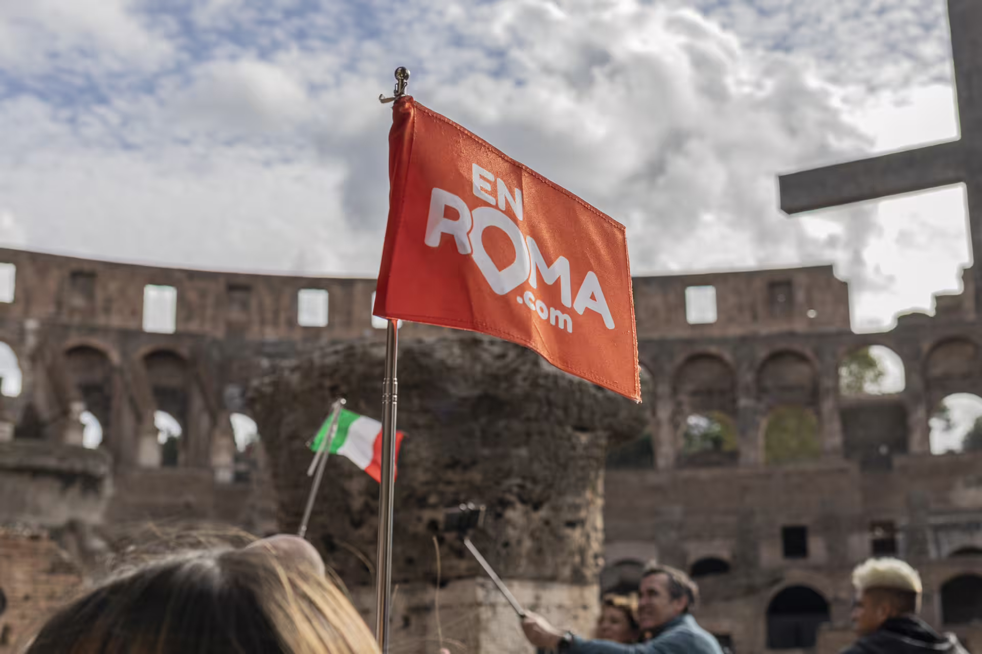 Bandera de tour En Roma frente al Coliseo de Roma, punto de encuentro para visita guiada Arena, Foro y Palatino