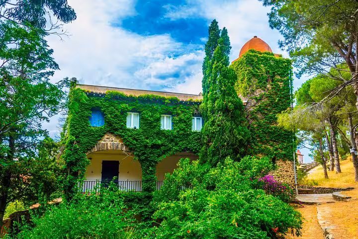 Ivy-covered historic stone villa with tower and lush gardens in Collioure, France