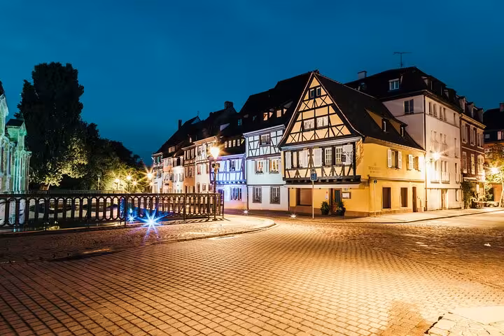 Colmar old town half-timbered buildings illuminated at night with cobblestone street