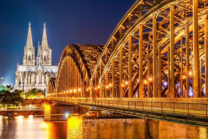Hohenzollern Bridge and Cologne Cathedral illuminated at night over the Rhine River