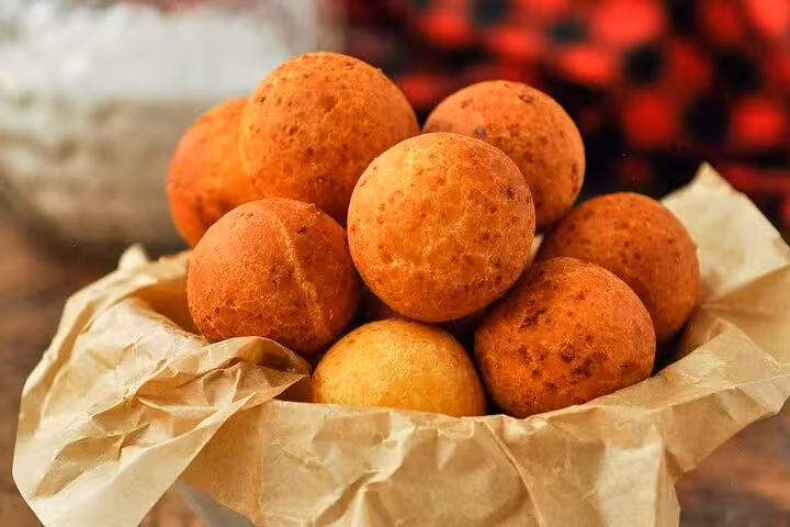 Golden buñuelos in a paper-lined basket, showcasing authentic Colombian street food in Medellín's Laureles.