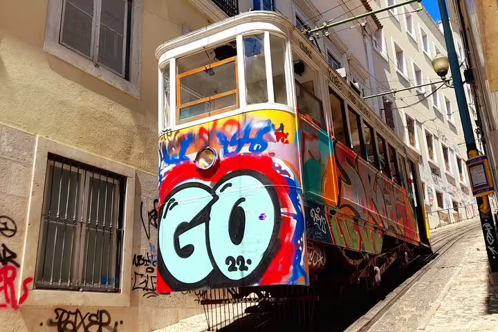 Colorful graffiti-covered tram on a steep street, perfect for a vibrant walking tour experience.