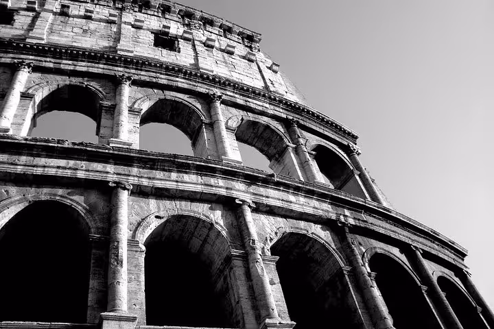 Dramatic black and white view of the Colosseum's arches, highlighting the ancient Roman architecture.