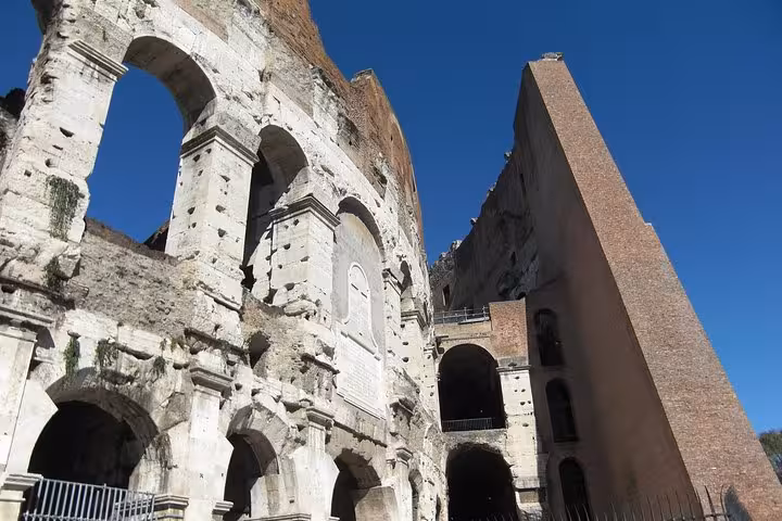 Close-up of the Colosseum exterior showcasing ancient Roman architecture under a clear blue sky.