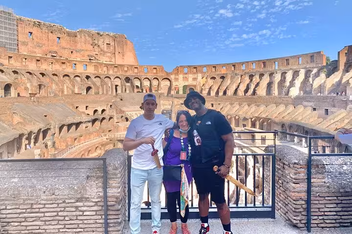 Visitors posing inside the historic Colosseum, showcasing its ancient architecture during a captivating guided tour experience.