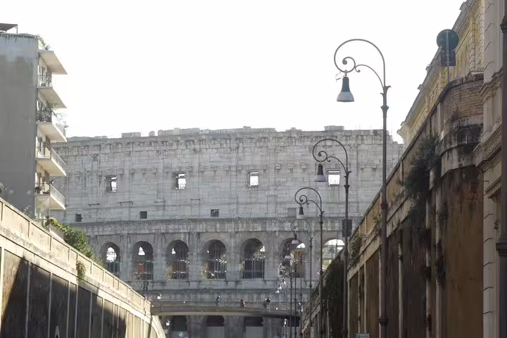 Iconic view of the Colosseum framed by Rome's historic streets on a Monti District sightseeing tour
