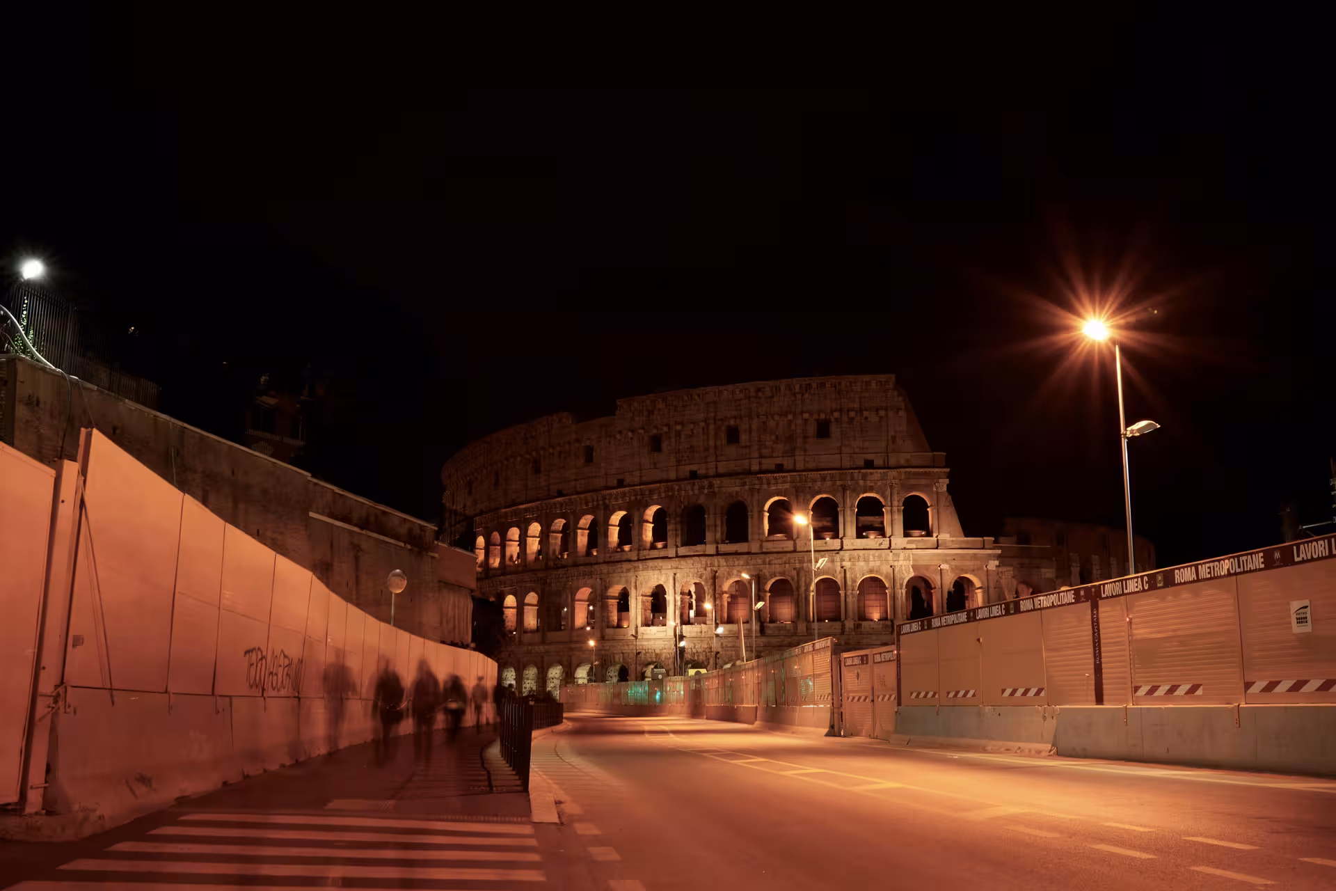 Colosseum glowing under night sky during Hidden Rome by Night golf cart tour.