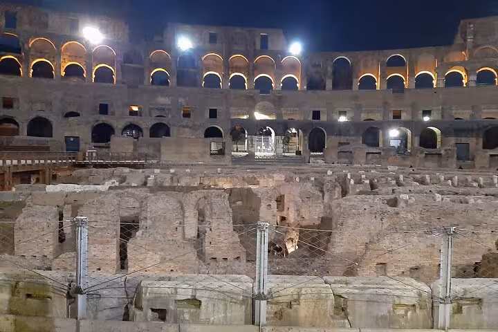 Explore the illuminated interior of the Colosseum at night on a guided tour showcasing ancient Roman architecture.