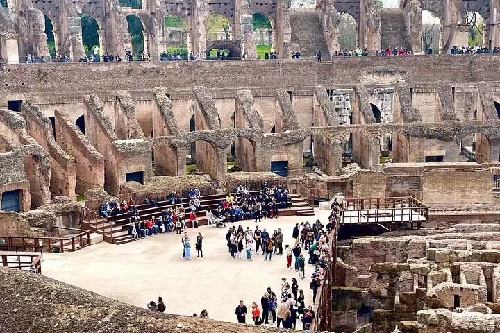 Guided tour group exploring the underground arena floor of the Colosseum in Rome with fast track entrance access