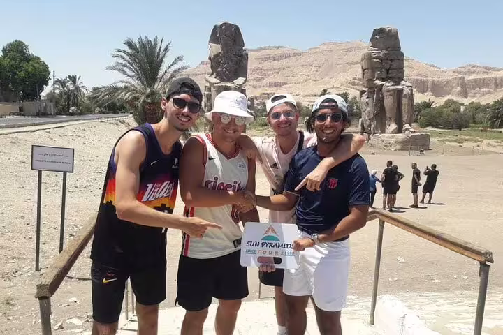 Friends at the Colossi of Memnon stop on a private overnight Luxor tour from Cairo by flight package