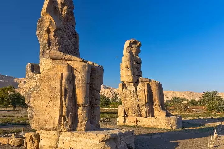 Colossi of Memnon statues at sunrise on Luxor West Bank, Egypt, must-see stop on Luxor day tour