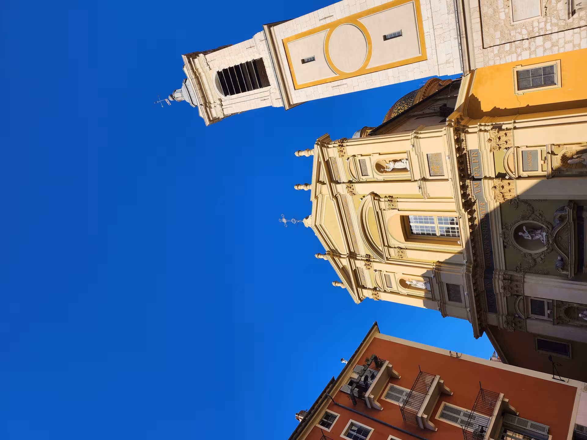 Stunning architectural facade of a historic church in Nice, against a clear blue sky, highlighting cultural landmarks.