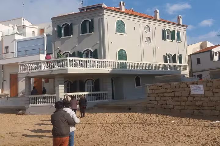 Tourists gather outside the iconic seaside house from Il Commissario Montalbano in Punta Secca, Sicily, Italy.
