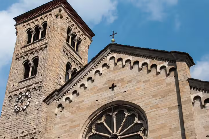 Historic stone church with bell tower and rose window in Como, Italy