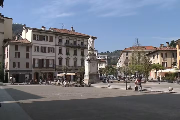 Piazza in central Como with statue and cafes near Lake Como, seen on a guided city boat tour itinerary