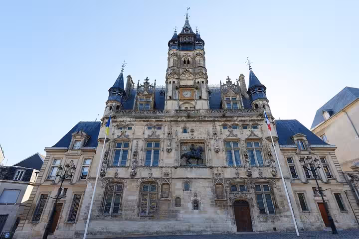 Ornate Renaissance facade of Compiègne City Hall with clock tower, turrets, and equestrian statue, France