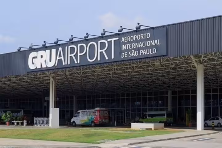 Exterior view of São Paulo's Congonhas Airport, featuring the main terminal entrance and parked vehicles.