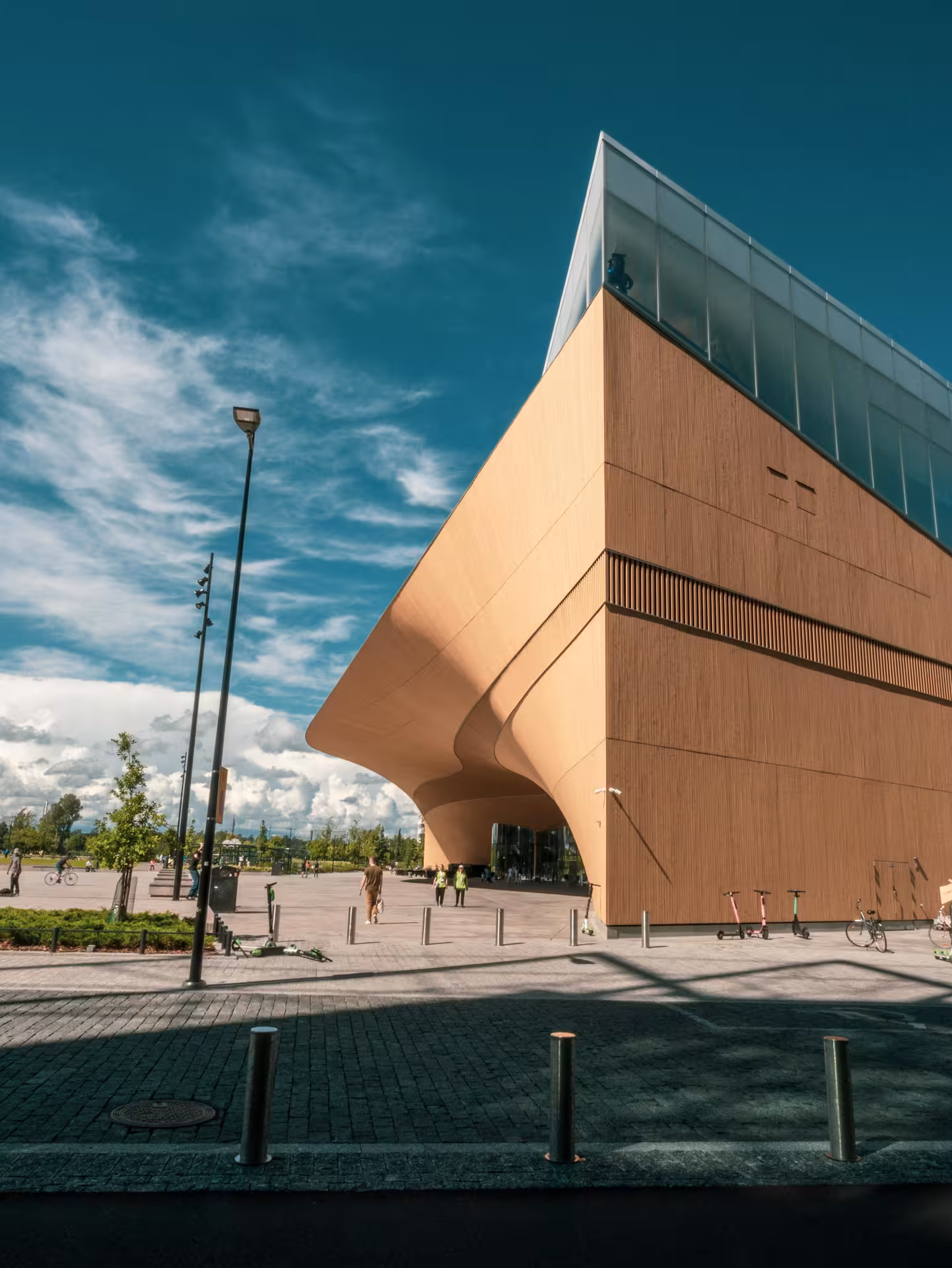 Striking contemporary design of a wooden building against a blue sky, highlighting modern architecture on the tour.