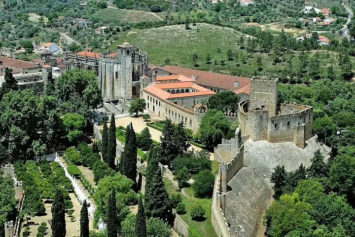 Aerial view of the historic Convent of Christ in Tomar, Portugal, surrounded by lush greenery on a private tour from Lisbon.