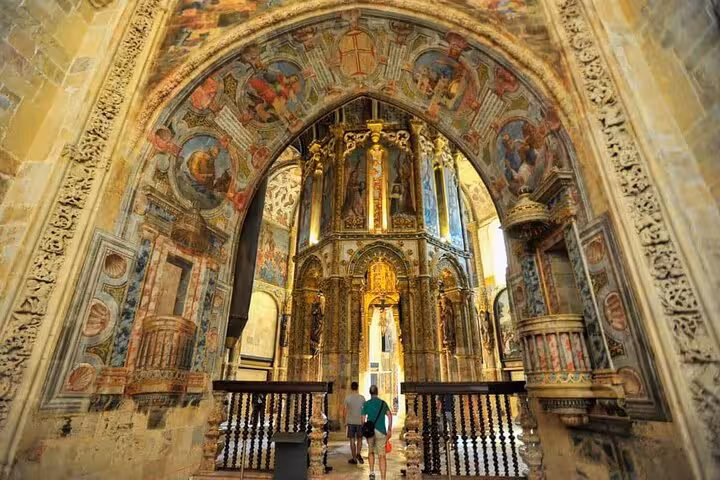 Intricate interior of the Convent of Christ in Tomar, featuring ornate arches and detailed frescoes.