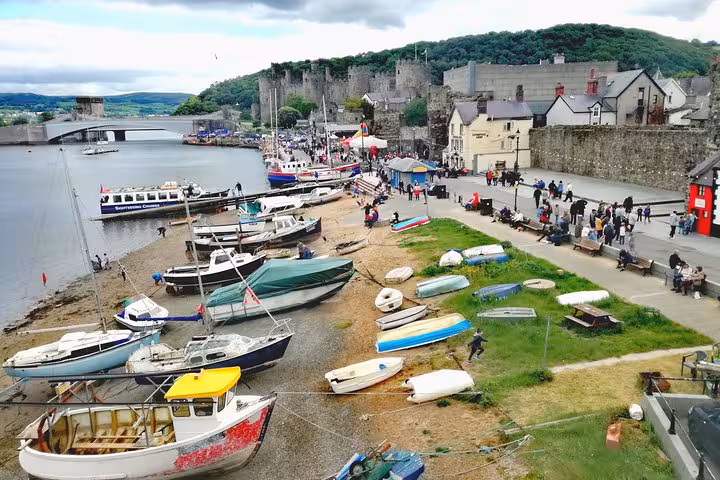 Conwy harbour boats with Conwy Castle and town walls, scenic stop on Snowdonia & 3 Castles Tour
