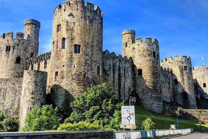Conwy Castle medieval stone towers on the Snowdonia & 3 Castles Tour in North Wales under blue skies