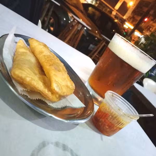 Savor a cold beer and crispy pastéis with hot sauce at a street bar on the Copacabana Botequim Experience tour.