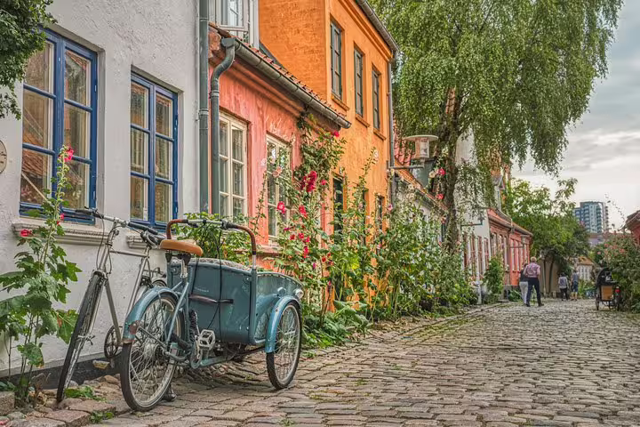 Charming cobblestone street in Copenhagen with colorful historic buildings and bicycles, perfect for a private full-day tour exploration.