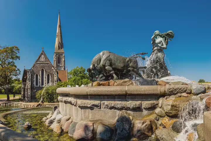 Gefion Fountain and St. Alban's Church under a clear blue sky in Copenhagen, perfect for a private walking tour exploration.