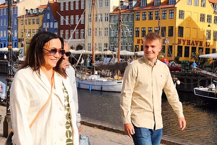Tourists enjoying a stroll along the picturesque Nyhavn canal, experiencing culture and charm on a walking tour in Copenhagen.