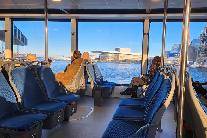 Passengers enjoy scenic views of Copenhagen Opera House from a ferry during the Walk & Ferry tour.