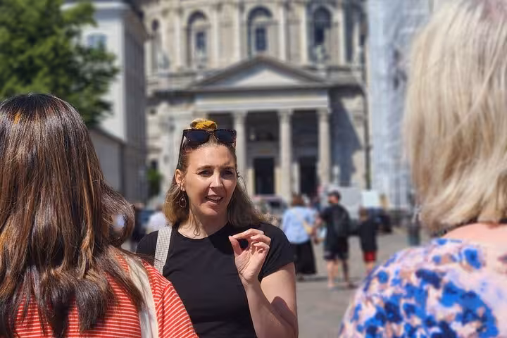 Tour guide explaining historical sites to tourists near Copenhagen's Marble Church.