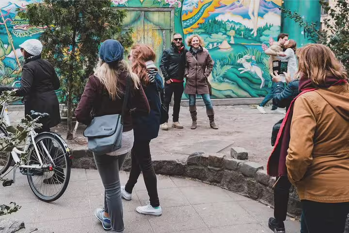Tourists explore vibrant street art in Vesterbro and Christianshavn during a Copenhagen alternative private tour.