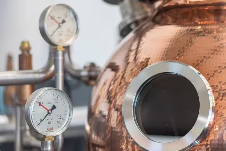 Close-up of a copper rum distillery tank with pressure gauges, highlighting artisanal production on a Sunny Southwest tour.