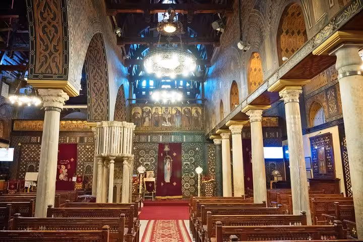 Coptic Cairo cathedral nave with ornate columns and chandeliers, included on Cairo city tour
