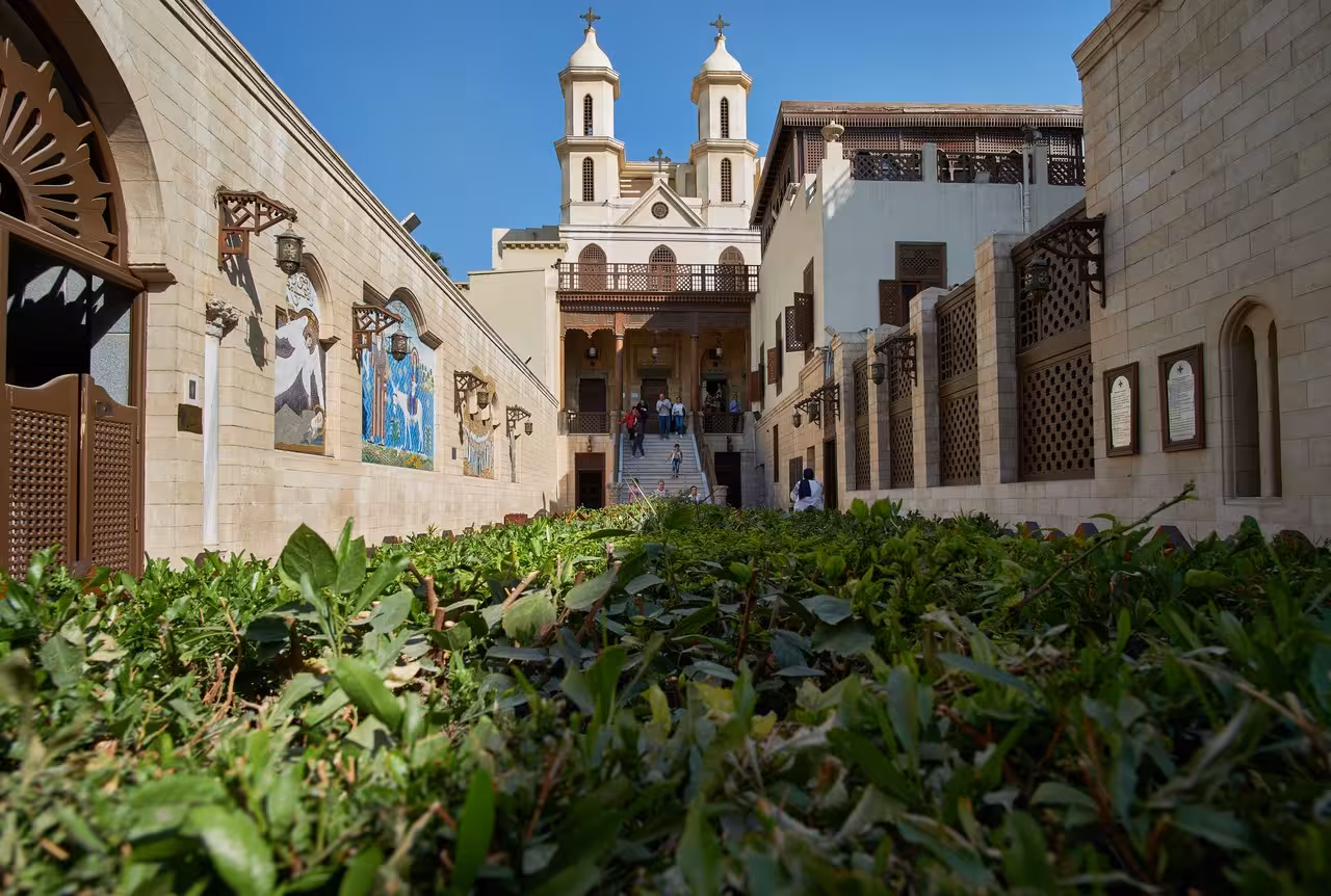 Coptic Cairo church courtyard with mosaics and twin towers, cultural stop on 8-day 5-star Egypt itinerary