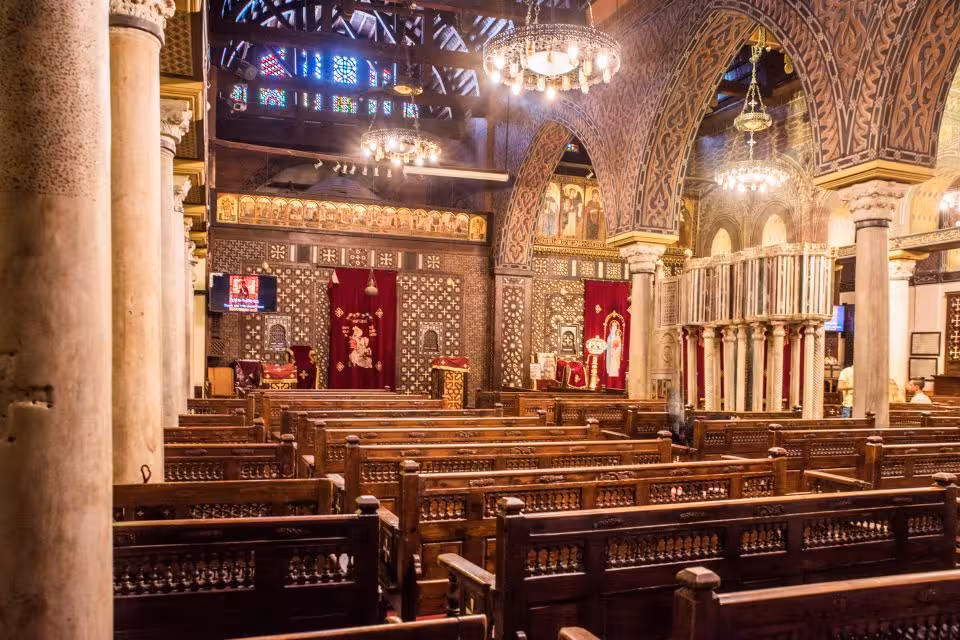 Historic Coptic Cairo church nave with wooden pews and carved arches, featured on Islamic and Coptic Cairo tour