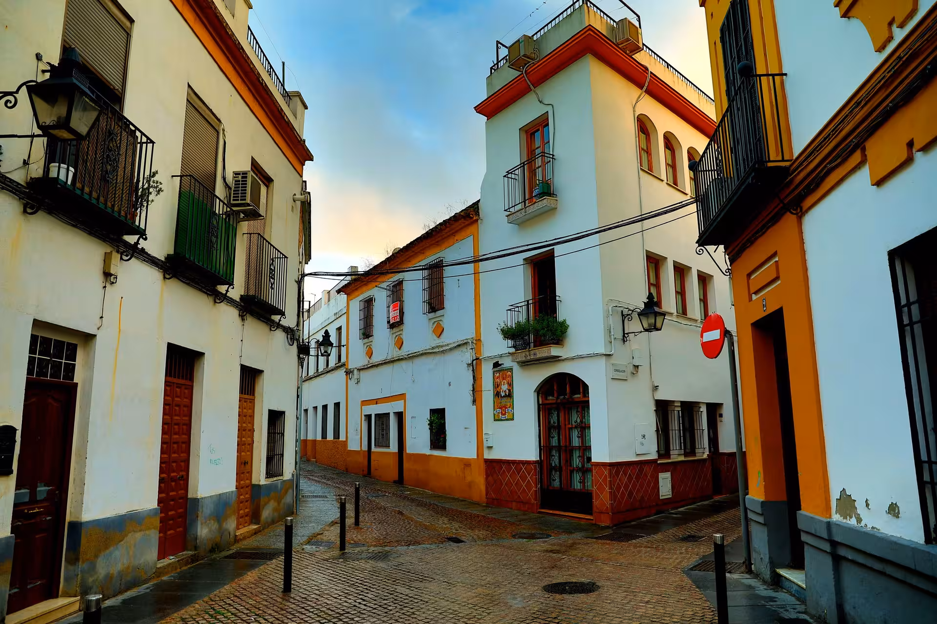 Charming intersection in Cordoba's Jewish Quarter with historic architecture and cobblestone streets at sunset.