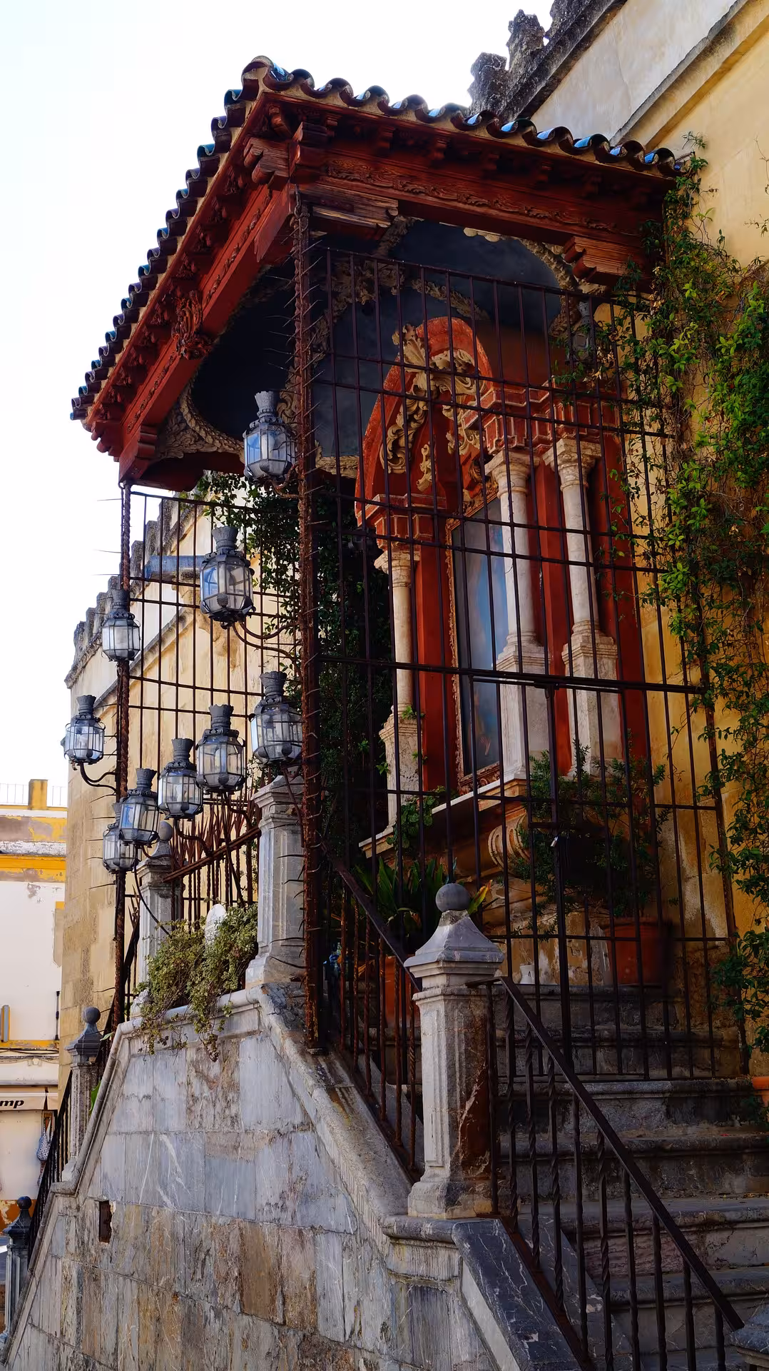Charming entrance with wrought iron lanterns and lush vines at the historic Jewish Quarter in Cordoba.