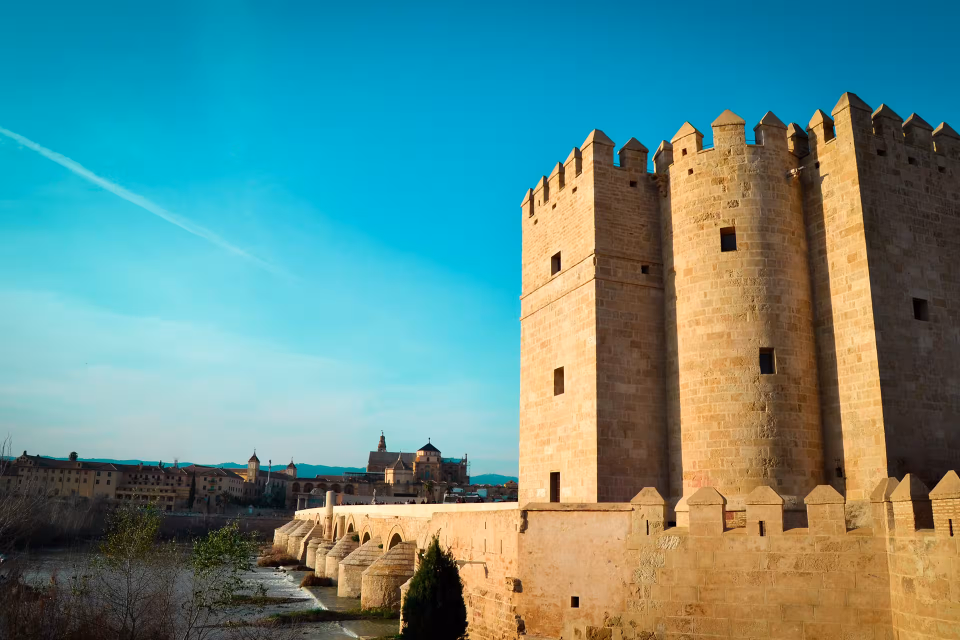 Explore Córdoba's iconic Roman Bridge and Calahorra Tower under a clear blue sky on this comprehensive city tour.