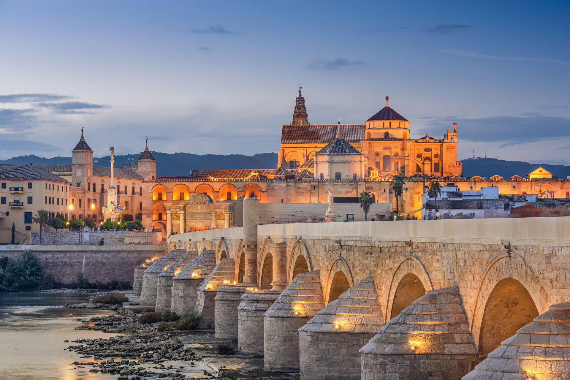 Roman Bridge and Mezquita-Cathedral at dusk in Cordoba, Spain, highlight stop on 1-day walking audioguide tour