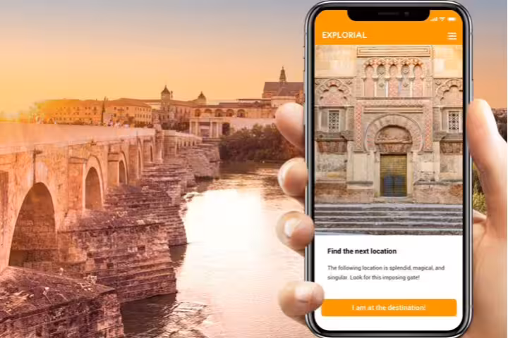 Córdoba scavenger hunt walking tour app with Mezquita gate clue by Roman Bridge at sunset