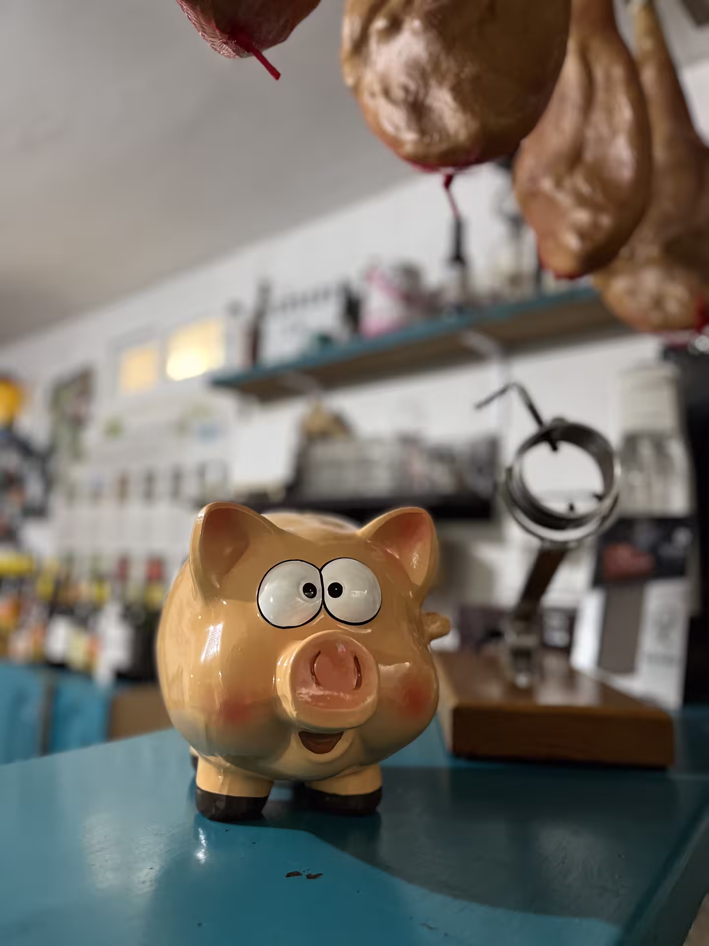 A playful piggy bank decorates a Cordoba tasting venue, surrounded by hanging cured meats.