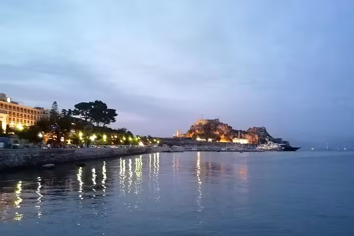Evening Corfu waterfront lights reflecting on the Ionian Sea during a locals BBQ boat cruise experience