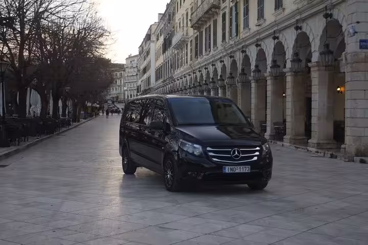 Luxury private transfer van in Corfu Old Town arcade, seamless airport and port pickup with driver