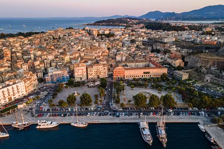 Aerial harbor view of Corfu Town at sunset with yachts and Old Fortress on a private day tour