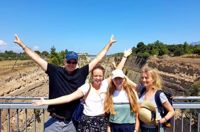Happy travelers posing at the Corinth Canal viewpoint on a private Athens day tour to Epidaurus and Ancient Corinth
